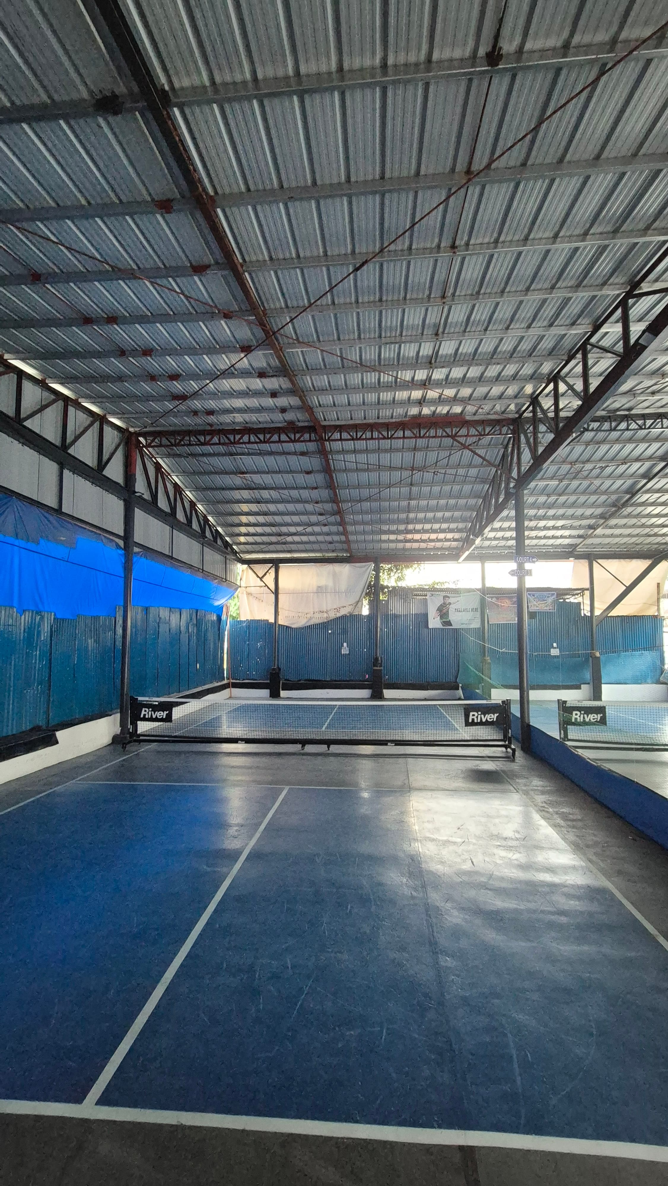 Court 3 — blue pickleball court under the covered steel-roofed pavilion